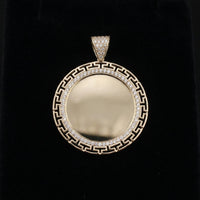 Gold pendant with diamond accents on a black background