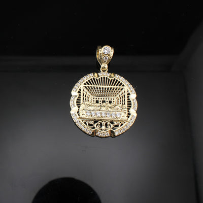 Gold pendant with intricate design and clear stones on a dark background